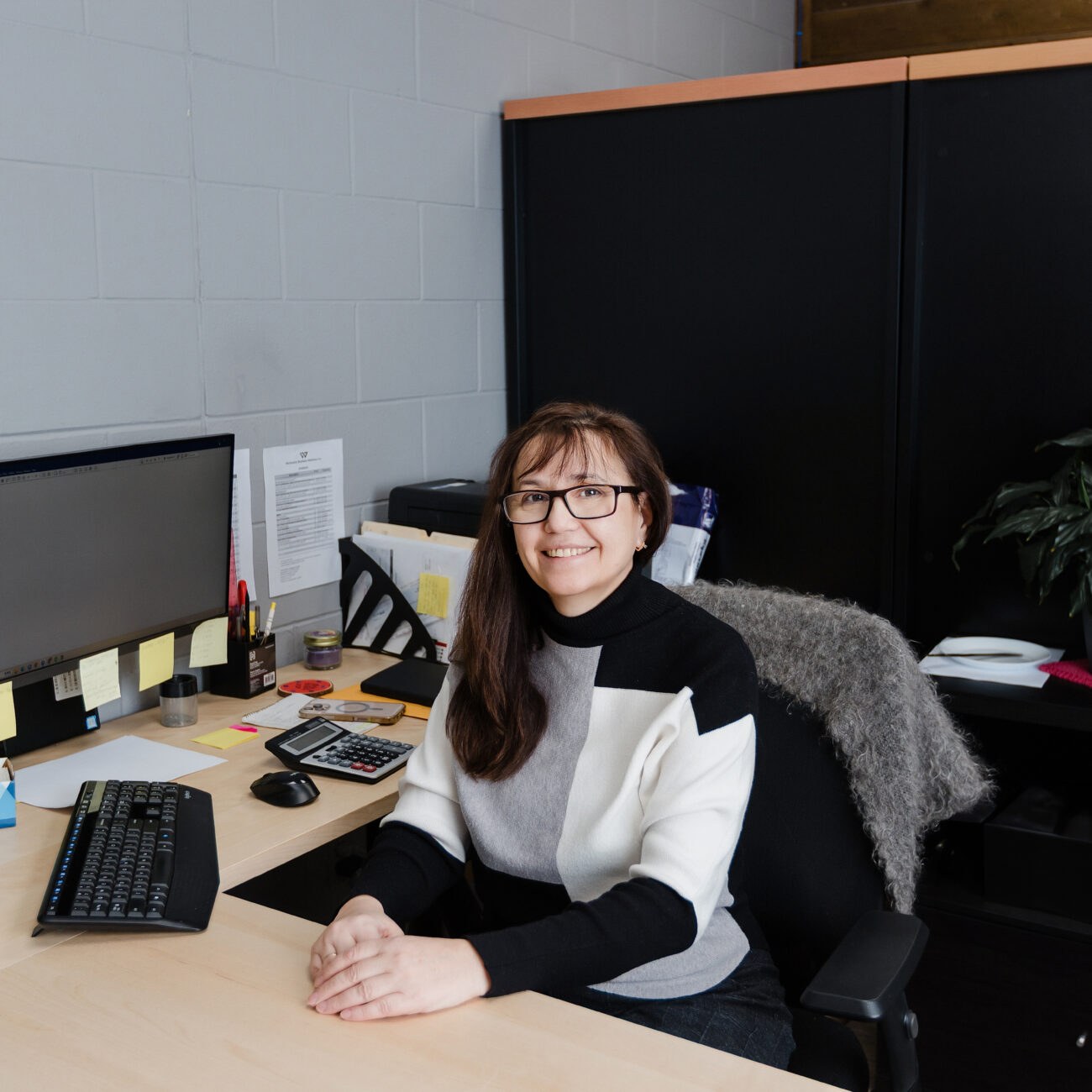 A Warkentin bookkeeper at her workstation with a calculator
