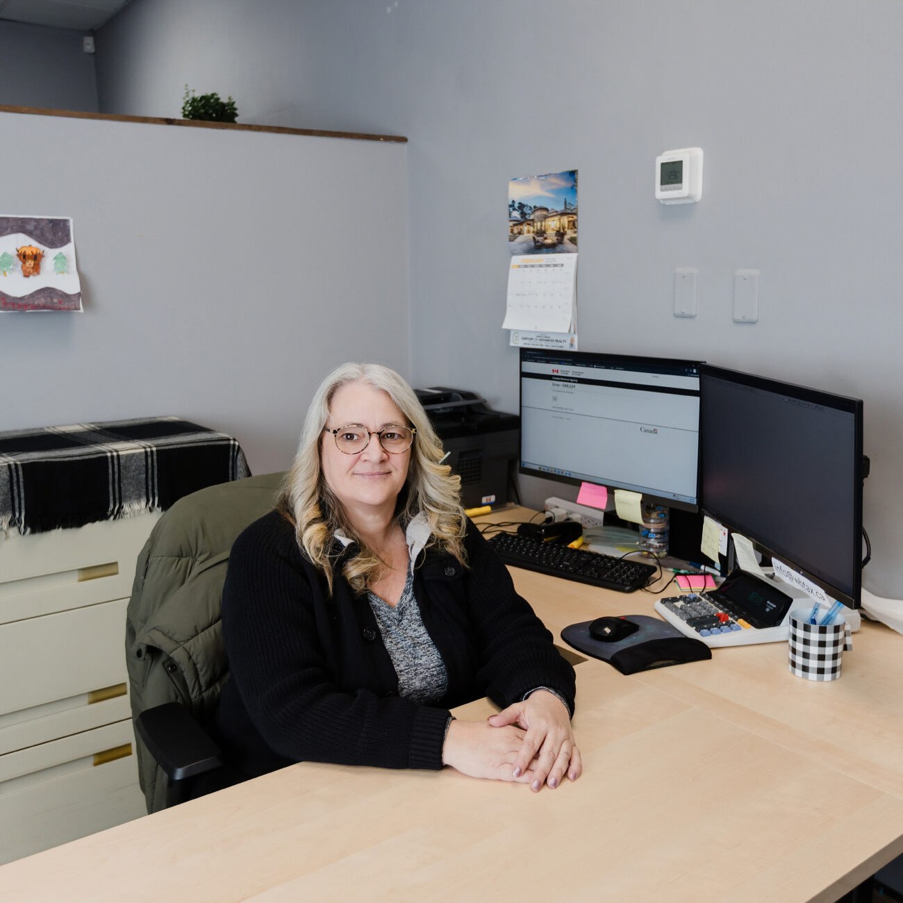 A Warkentin team member at her desk, the office email address on her monitor
